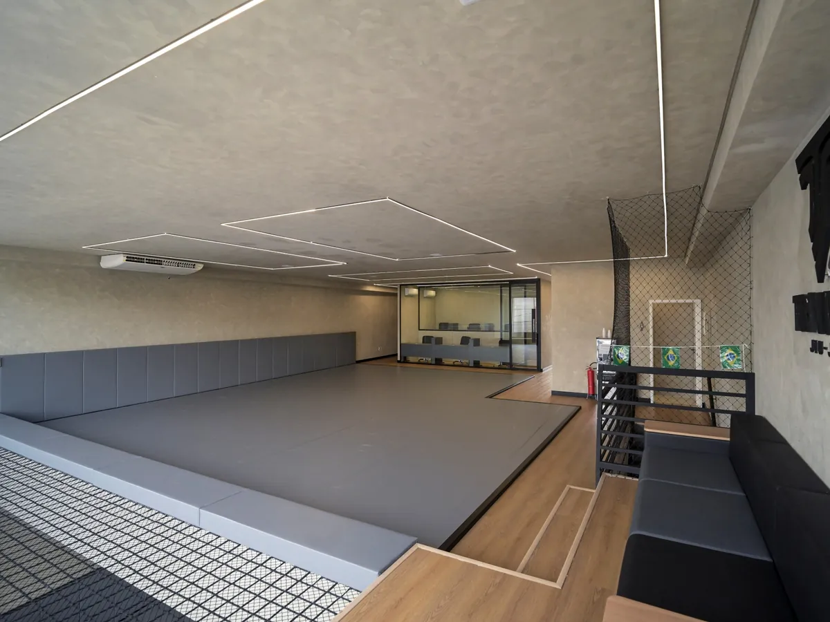 Tatame do andar superior da Trivium Jiu-Jitsu, com sofá ao lado