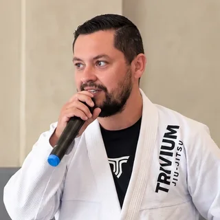 Alexandre Minato, sócio-fundador da Trivium Jiu-Jitsu, de kimono no tatame da academia